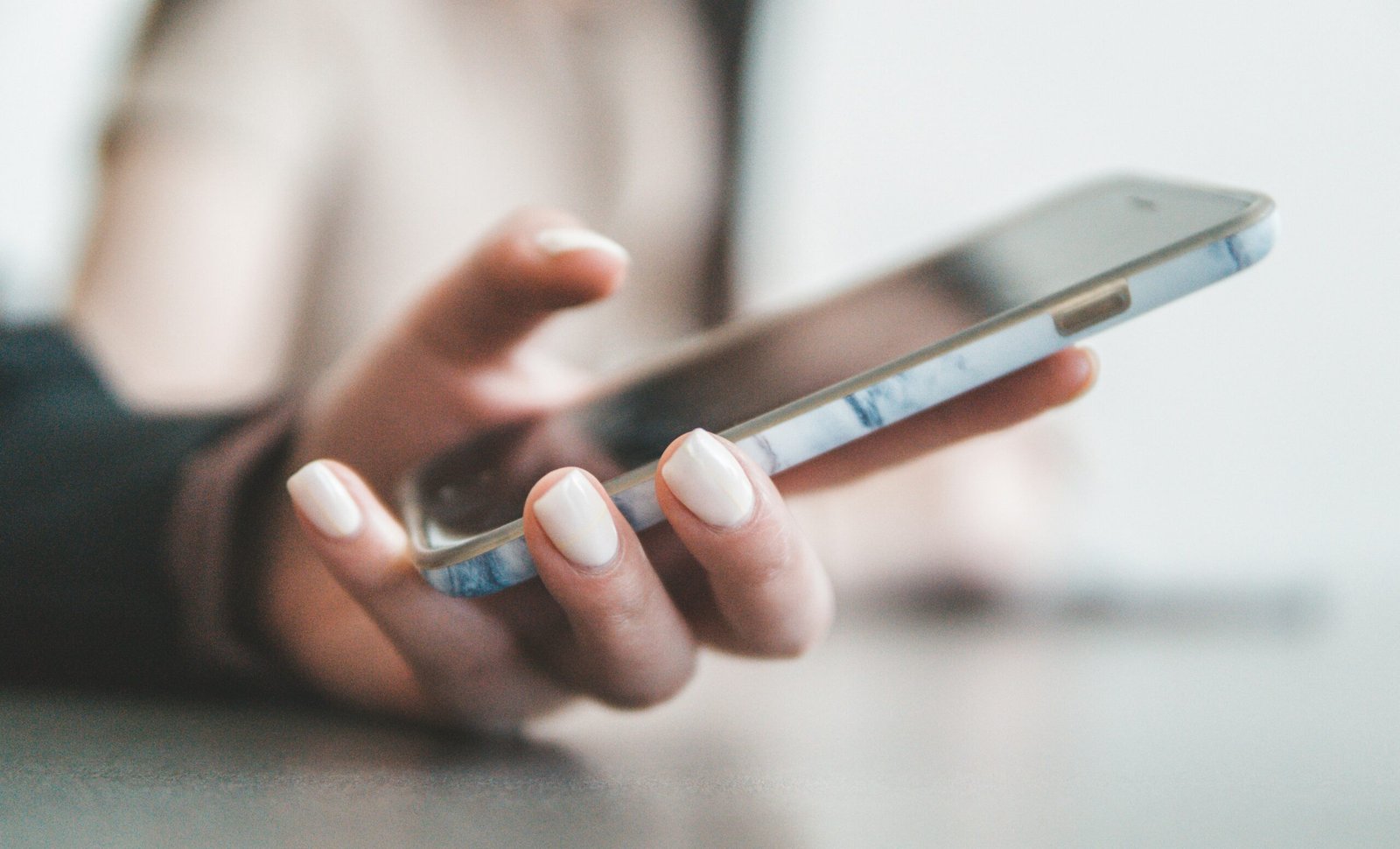Close up of hands holding smartphone reviewing audio messaging notes and client tasks