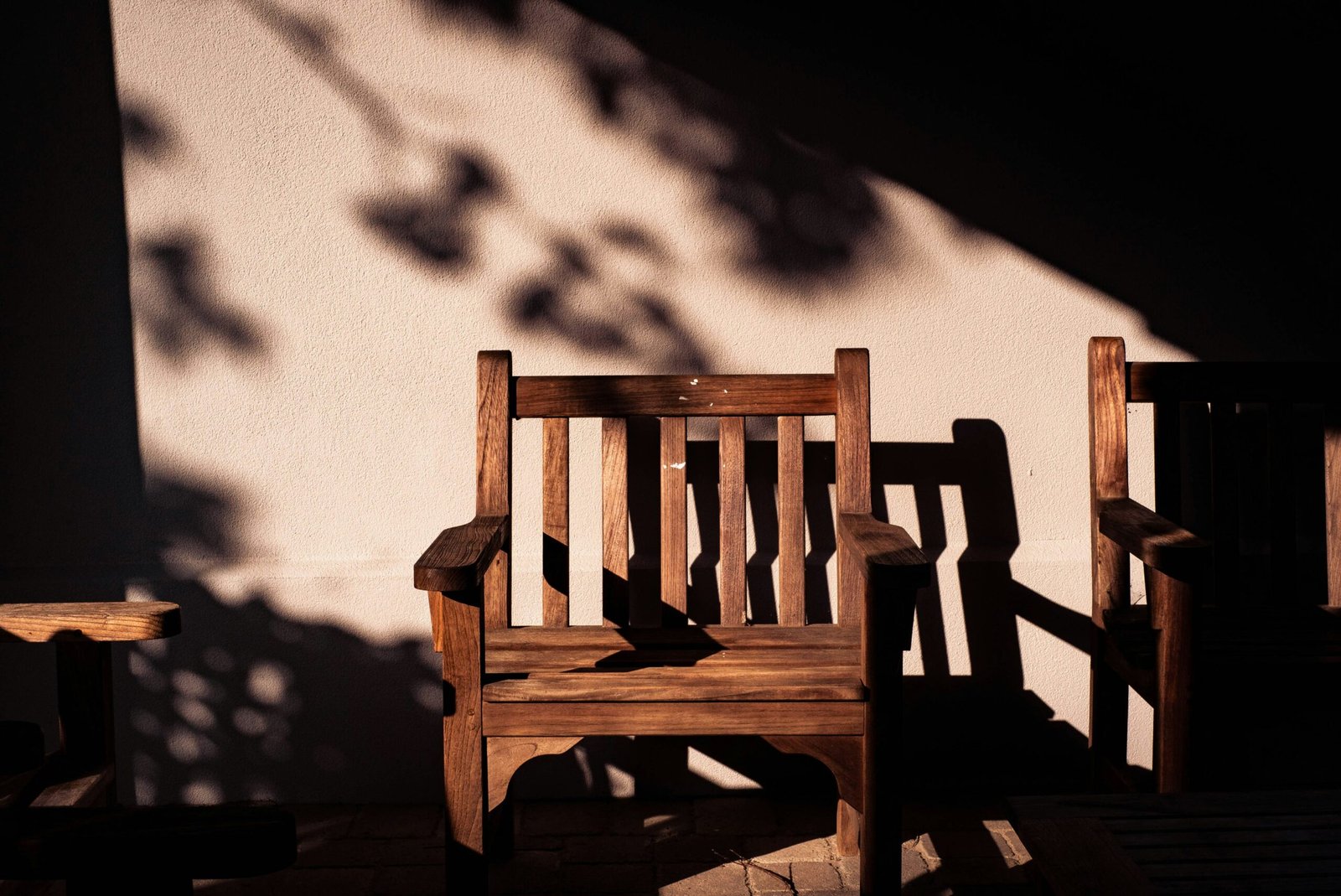 Empty wooden chair sitting in a pool of sunlight in a spacious quiet room